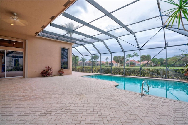 view of pool with glass enclosure and a patio area