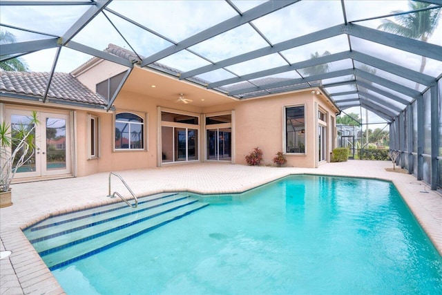 view of swimming pool with french doors, a patio area, ceiling fan, and a lanai