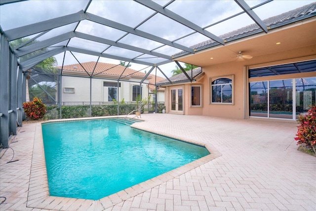 view of pool featuring glass enclosure and a patio