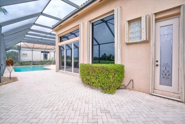 view of pool with glass enclosure and a patio