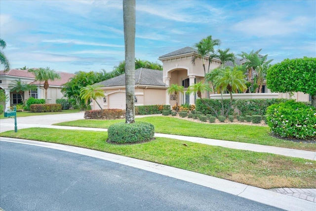 mediterranean / spanish-style house featuring a front lawn and a garage