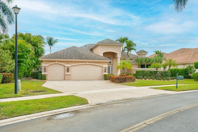 mediterranean / spanish-style house featuring a garage and a front lawn