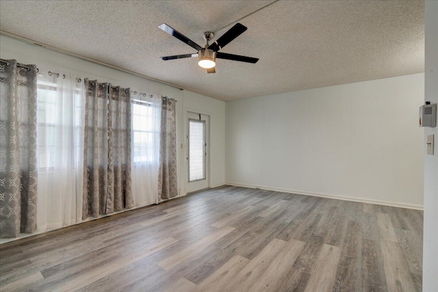 empty room featuring a textured ceiling, hardwood / wood-style flooring, and ceiling fan