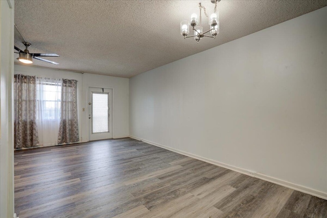 unfurnished room with ceiling fan with notable chandelier, a textured ceiling, and hardwood / wood-style flooring