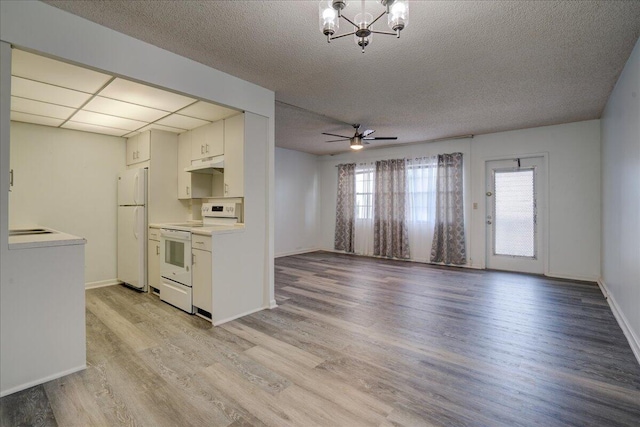 kitchen with white cabinetry, ceiling fan with notable chandelier, white appliances, and light wood-type flooring