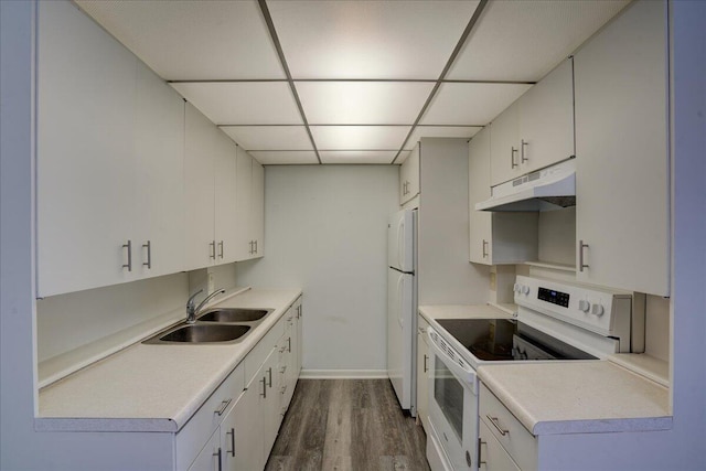 kitchen with a paneled ceiling, white appliances, sink, wood-type flooring, and white cabinetry