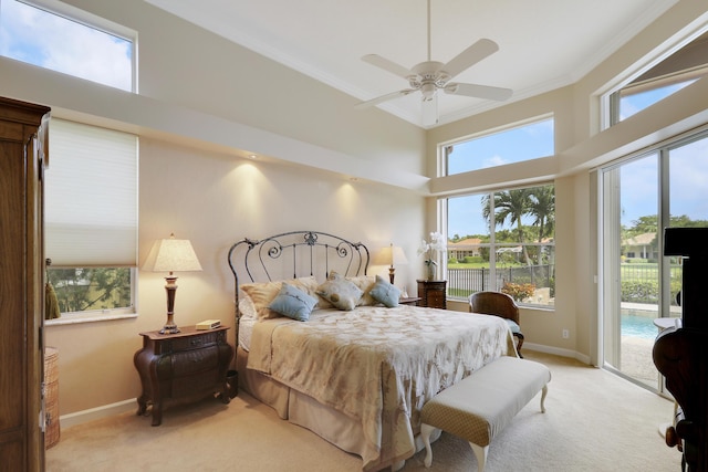 bedroom featuring multiple windows, ceiling fan, light carpet, and access to outside