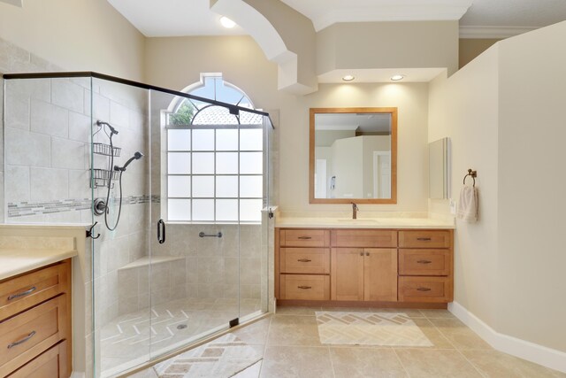 bathroom with vanity, ornamental molding, tile patterned floors, and walk in shower