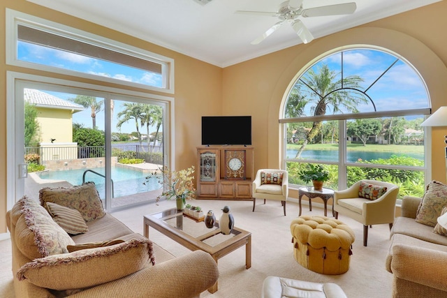 carpeted living room with ornamental molding and ceiling fan