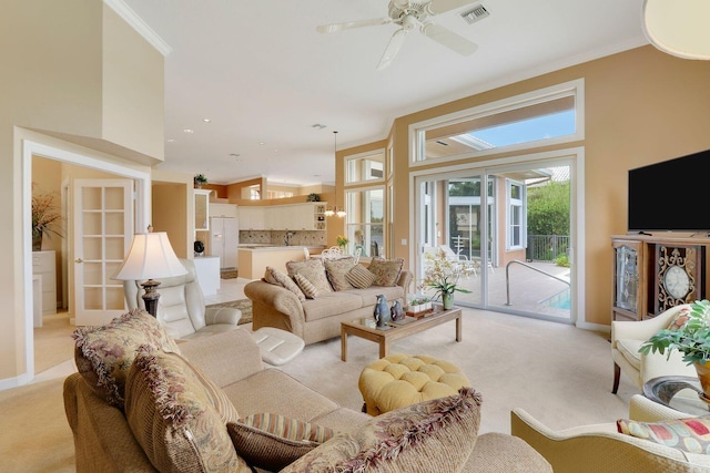 living room with light carpet, crown molding, and ceiling fan