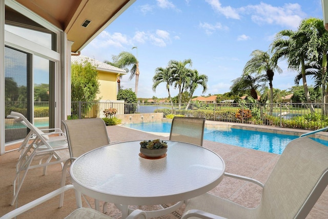 view of pool with a patio area and a water view