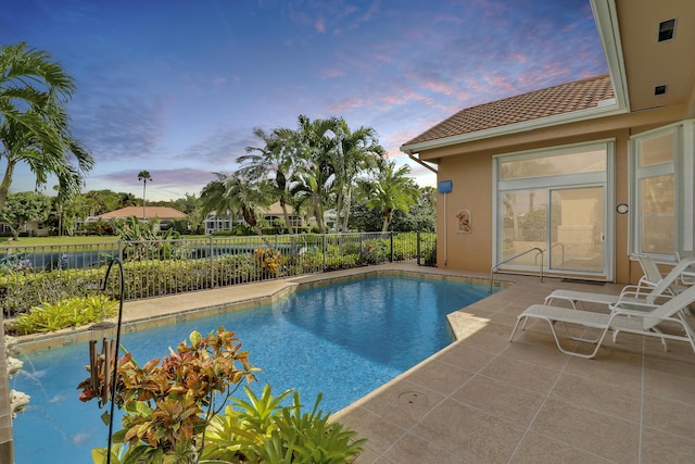 pool at dusk featuring a patio area