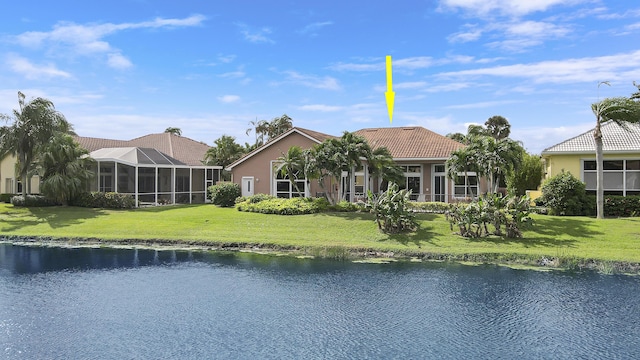 exterior space with a front lawn, glass enclosure, and a water view