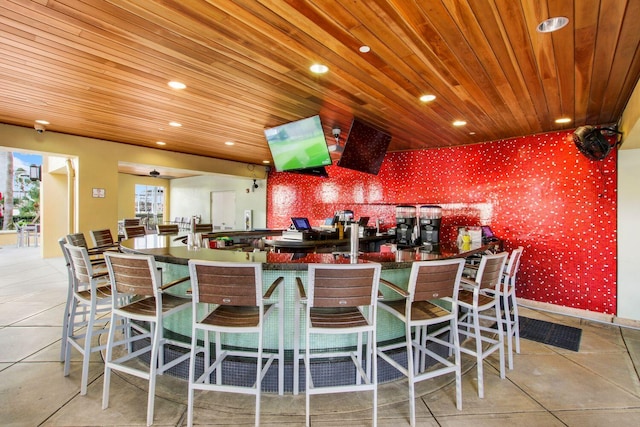 kitchen featuring light tile patterned floors, a kitchen bar, and kitchen peninsula