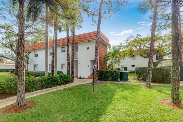 view of front of home with a front yard and a balcony