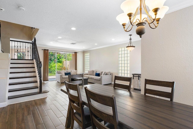 dining area with a textured ceiling, ornamental molding, dark wood-type flooring, and a chandelier