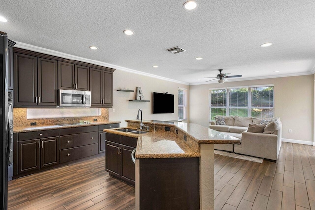 kitchen with an island with sink, dark hardwood / wood-style floors, and ornamental molding