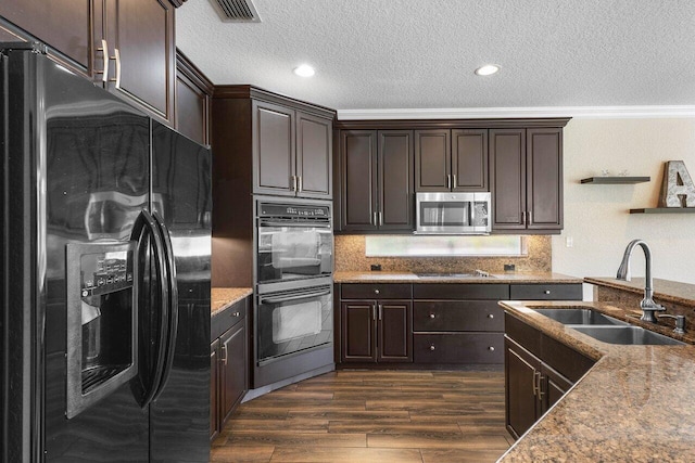 kitchen featuring dark brown cabinetry, sink, dark hardwood / wood-style flooring, black appliances, and ornamental molding