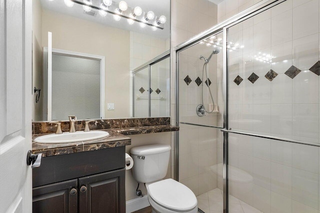 bathroom featuring vanity, toilet, and a shower with shower door