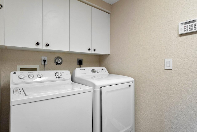 washroom featuring cabinets and separate washer and dryer