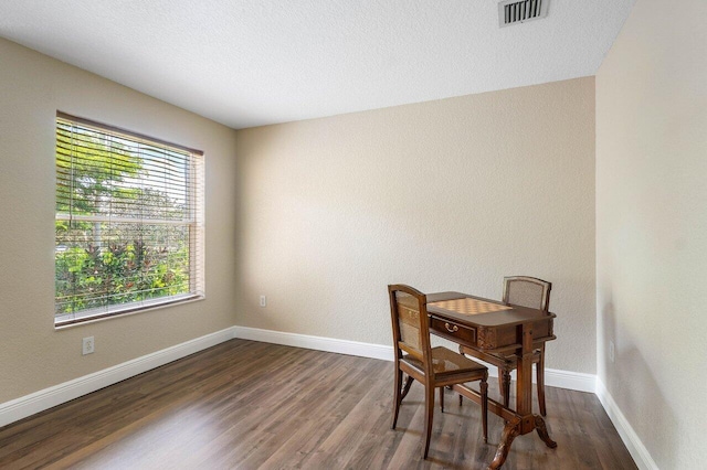 dining room with a textured ceiling and dark wood-type flooring