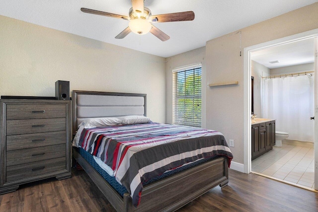 bedroom featuring ensuite bathroom, dark hardwood / wood-style flooring, and ceiling fan