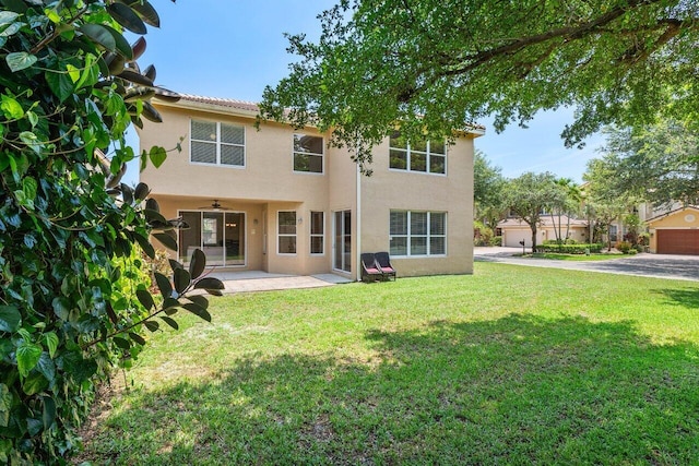 rear view of house with a lawn, ceiling fan, and a patio area