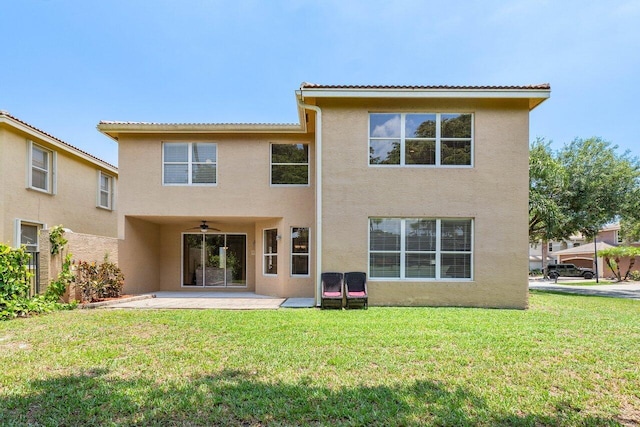 back of house featuring a yard, ceiling fan, and a patio area