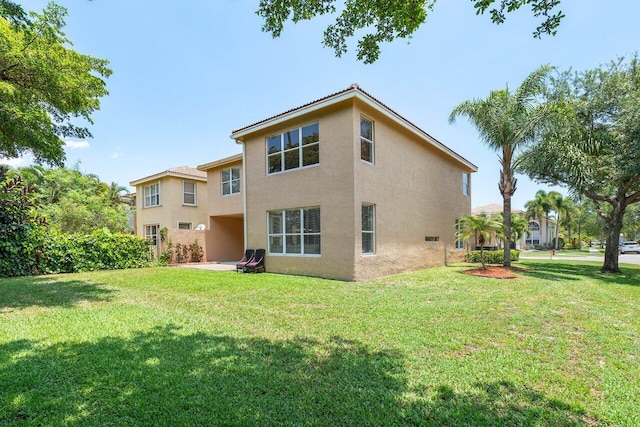 rear view of house featuring a yard