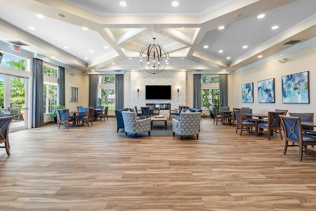 living room with crown molding, a healthy amount of sunlight, and coffered ceiling