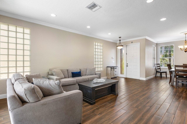 living room featuring a chandelier, a textured ceiling, dark hardwood / wood-style flooring, and crown molding