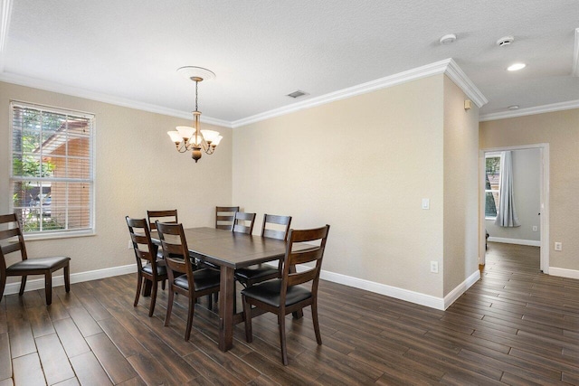 dining space featuring a textured ceiling, ornamental molding, dark wood-type flooring, and a chandelier