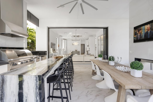 interior space featuring a breakfast bar area and ceiling fan