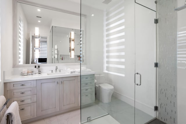 bathroom with vanity, toilet, and a shower with shower door