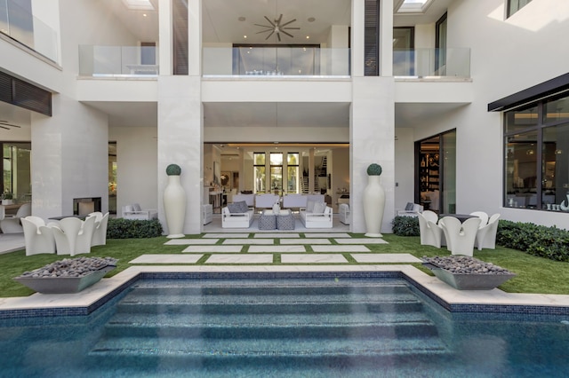 back of property with outdoor lounge area, a patio, and ceiling fan