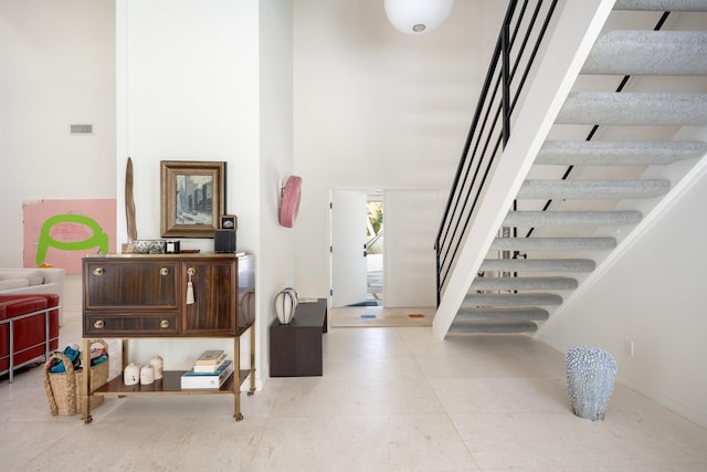 stairs featuring a towering ceiling