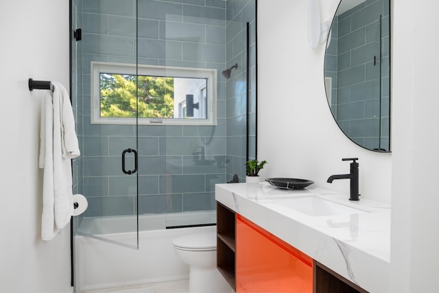 full bathroom with vanity, enclosed tub / shower combo, and toilet