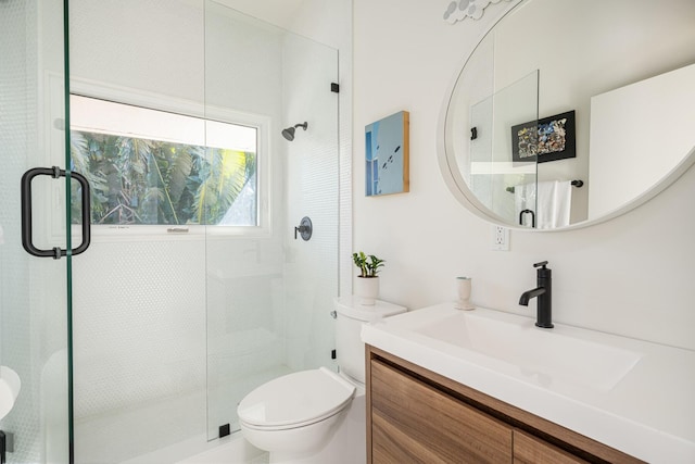 bathroom featuring vanity, toilet, and walk in shower