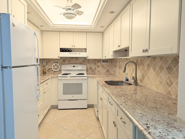 kitchen featuring white appliances, white cabinets, a raised ceiling, sink, and light tile patterned flooring