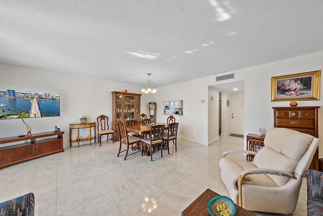 dining area with a textured ceiling, a chandelier, and light tile patterned floors