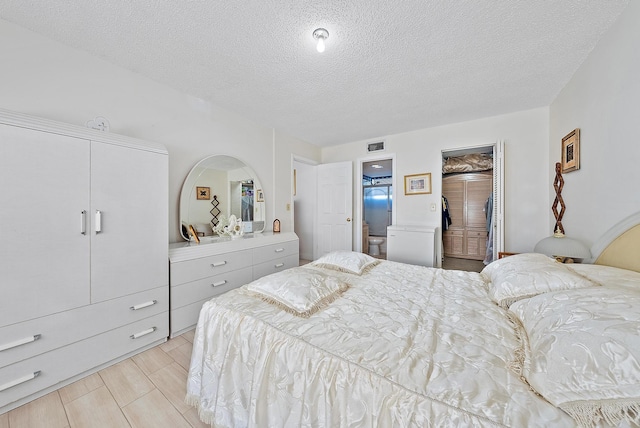 bedroom featuring a textured ceiling, a closet, and connected bathroom