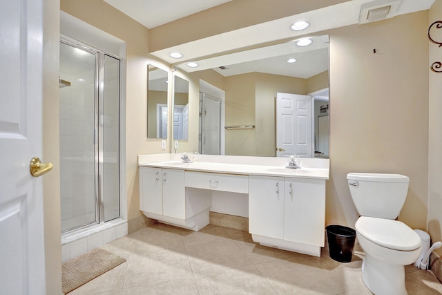 bathroom featuring tile patterned flooring, vanity, a shower with door, and toilet