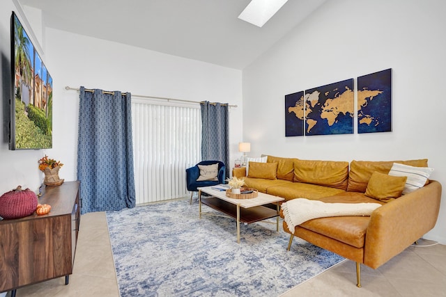 living room featuring light tile patterned flooring, a skylight, and high vaulted ceiling