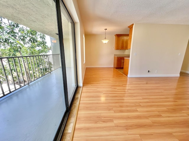 interior space with a textured ceiling and light hardwood / wood-style flooring