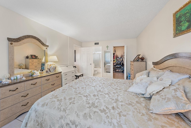 bedroom with a spacious closet, a closet, and a textured ceiling