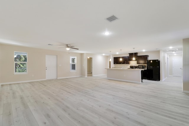 unfurnished living room featuring light wood-type flooring and ceiling fan