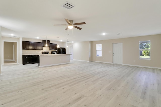 unfurnished living room featuring ceiling fan and light hardwood / wood-style floors