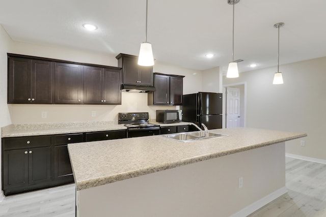 kitchen with pendant lighting, sink, an island with sink, and black appliances