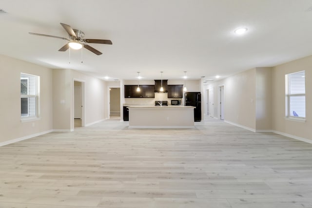 unfurnished living room featuring ceiling fan and light wood-type flooring