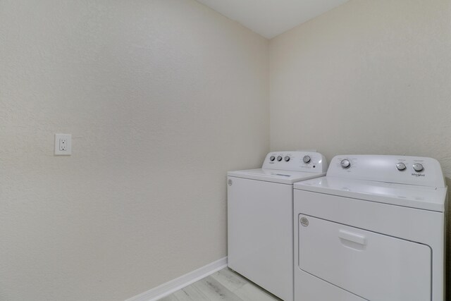 laundry area featuring independent washer and dryer and light wood-type flooring